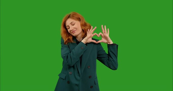 Heart sign on green background woman with love gesture for support. Romantic care or mockup kindness portrait of female chroma key model on studio background.