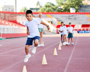 Fototapeta premium child sport athlete childhood girl competition fun young outdoor active exercise kid running fitness training athletic game healthy group play team school exercising