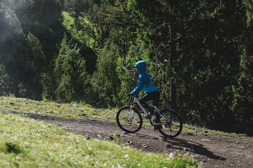 Obraz premium Woman riding mountain bike in forest mountain