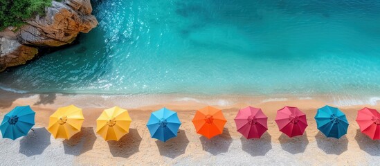 Fototapeta premium Aerial View of Colorful Beach Umbrellas on Sandy Shore