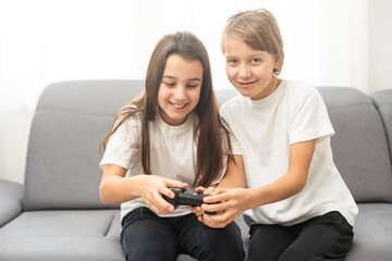 Two little girlfriends playing video game with joysticks. Excited and focused european children. Childhood concept. Entertainment and leisure. Idea of friendship. Grey background in studio. Copy space