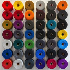 Colorful yarn rolls grid on white background with ample negative space for text placement