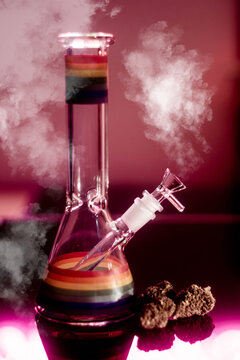 Glass bong cannabis and smoke on red neon background, space for text. Smoking device