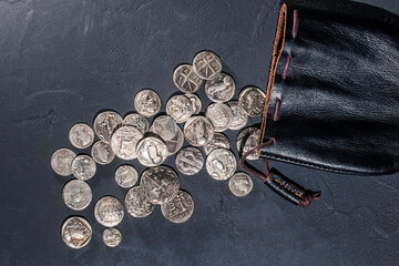 Leather pouch full of ancient silver coins © allexxandarx