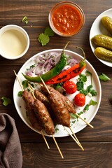 Homemade lula kebab with vegetables on wooden table