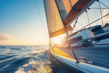 Fotobehang Photo of a sailing yacht on the sea, taken from the deck of the boat and looking to the bow with the sail billowing in wind. Suitable for travel or adventure concepts. © Mark G