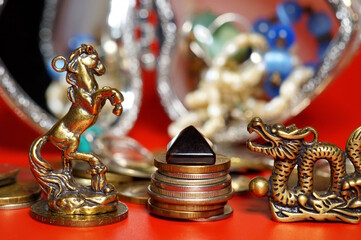 A statuette of a horse and a dragon with coins and a pyramid in black. Horoscope and astrology....