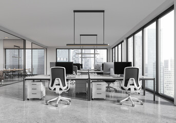 Glass coworking interior with armchairs and desks, pc monitors and window