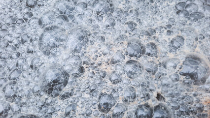 The brown foam floating on the surface of the water