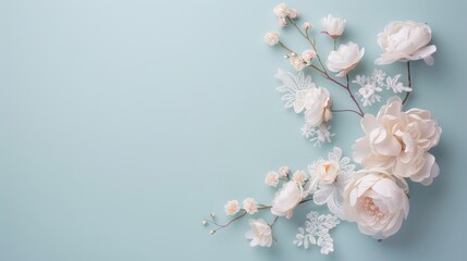 Fototapeta premium Elegant white floral arrangement against a soft pastel blue background, perfect for wedding invitations or romantic designs.