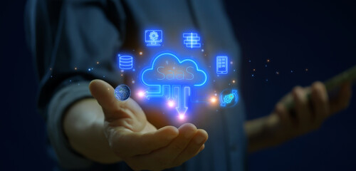 SaaS, software as a service concept for software services on cloud system. Internet and networking technology. Businessman using smartphone to show SaaS icons on virtual screen.