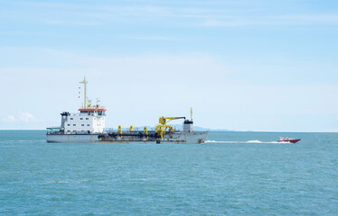 Dredgers are exploring the sea near the coast.