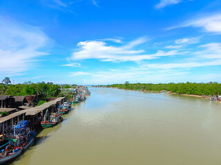 Fototapeta premium Blue sky background with clouds. Bright sky and clouds of the day. fishing village Located along the river, community and rural way of life. Long holiday, background for relaxation mood Relaxation.