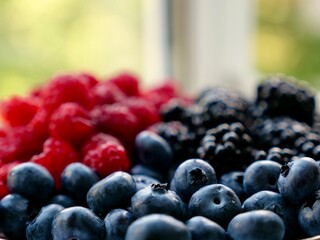 Colorful mix seasonal summer berries raspberries, blueberries, blackberries close-up, background. Healthy foods with antioxidants