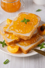 Apricot jam on bread in a white plate