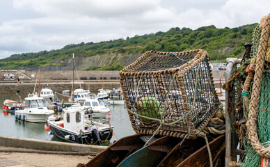 Close and selective focus of a fish trap, crab pot or lobster trap on the quayside in the harbour in the seaside town of Lyme Regis on the Jurassic coast