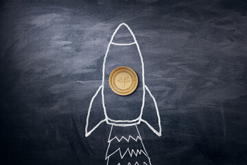 A chalk-drawn rocket on a blackboard, with a real coin representing the nose, symbolizing financial growth. 3D Rendering