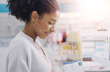 Happy, black woman and customer with box at pharmacy for side effects, symptoms or medical care at pharmaceutical store. Young African, female person or shopper reading product on healthcare benefits