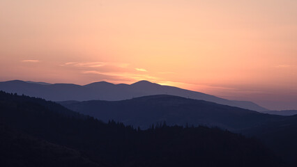 Orange sunset with the setting sun behind the mountains