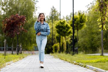 Woman Walking and Talking on Phone in Park