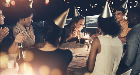 Group of people, celebration and birthday cake as happy, cheerful and excited in crowd at table. Female person, blowing candles and party with applause, friends and gathering for event in restaurant