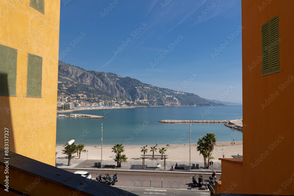 Wall mural View of Sablettes Beach between two buildings in Menton, Provence Alpes-Cote d'Azur, France.