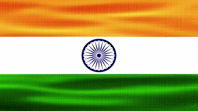 The Indian national flag, a tricolour of saffron, white, and green, is proudly waving in the wind. The white stripe features a navy blue Ashoka Chakra, representing the wheel of law and dharma.
