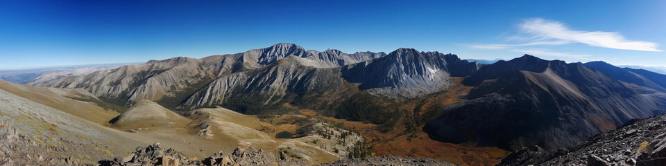 Naklejka premium Wide panoramic photo of the mountains against the blue sky