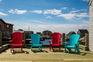 colorful chairs sit on a wharf in peggy's cove an iconic fishing village on the south shore of nova scotia room for text