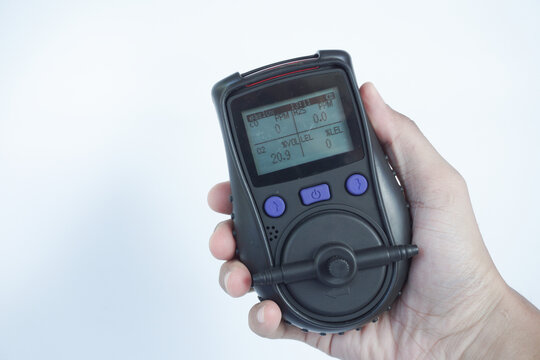 Human's hand holding the Portable Gas Detector for detect combustible gas , flammable gas , toxic gas and oxygen depletion in a confined spaces before starting work.