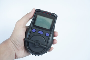 Human's hand holding the Portable Gas Detector for detect combustible gas , flammable gas , toxic gas and oxygen depletion in a confined spaces before starting work.