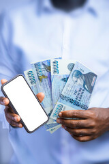 Black person holding Icelandic króna notes and showing phone with blank screen to the camera. Hand holding Iceland currency notes, 3d rendered money
