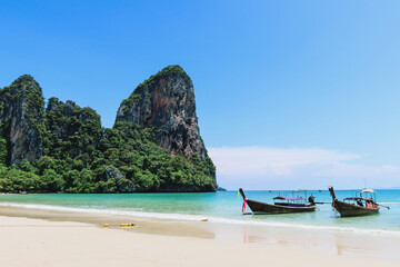 Fototapeta premium Typical long tail boat in Island in Krabi Thailand. Ao Phra Nang Beach wooden longtail boat on Railay Peninsula in front of Limestone karst rocks, close to Ao Nang, Krabi province, Thailand