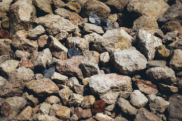 Stone rock background texture. Brown or black gravel or crushed stone for construction and reconstruction. Textured background. Construction industry.