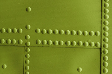 Riveted metal plates, painted and weathered green.