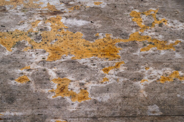 Fototapeta premium A wooden surface with a lot of cracks and holes. wallpaper wooden panels. Yellow washed And Scratched Rustic Wooden Background