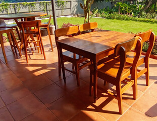Dining table with chair made of wood on the outside surround with garden green field