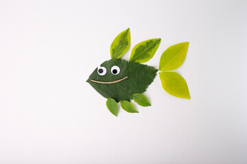 Creative fish crafted from leaves and natural materials. Large leaf body, smaller leaf fins. Googly...