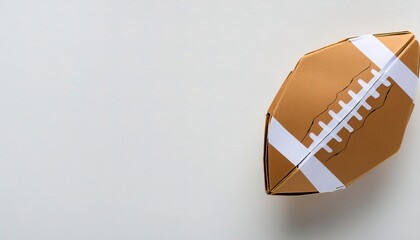 sports and competition paper origami concept of an American college high school junior striped or NFL football pigskin isolated on white background with copy space