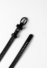 Women's belt in black with a metal buckle on a white background.