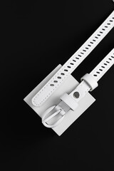 Women's belt in white with a metal buckle on a black background.