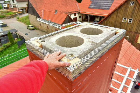Neu aufgebauter Beton-Sandstein mit zwei Schamotte-Innenrohren mit Baustahl-F&uuml;hrungen, Abschlussfolie und Abschlussprofil zum Feuchtigkeitsschutz am Schornstein-Kopf