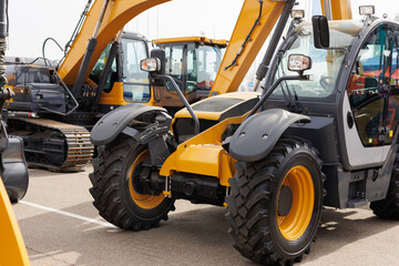 New mini excavators in the same row in the agricultural machinery store.