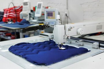 The process of sewing a riding saddle or a padded chair seat on a sewing machine.