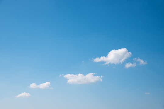 light blue sky with some tiny fluffy clouds