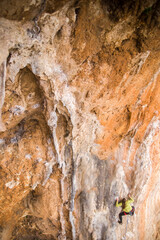 A rock climber climbs to the top of the mountains along a difficult route.