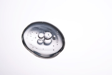 A smear of cosmetic gel close-up on a gray background. Appetizing texture with bubbles.