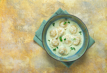 ravioli in cream sauce, spices and herbs, top view, no people,