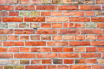 Obraz premium A brick wall as a background. Brown and red bricks. Antique wall finish. Picture for background, wallpapers, postcards.