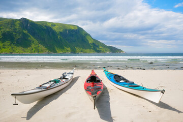 Kayaks on a sandy shore. Water sports. Active recreation and travel in summer time. Norway. Nature in fjords. Panoramic view. Traveling on a Norwegian fjord. Scandinavia